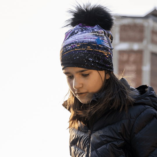 Close-up of a young girl wearing the Abracadabra beanie with abstract patterns