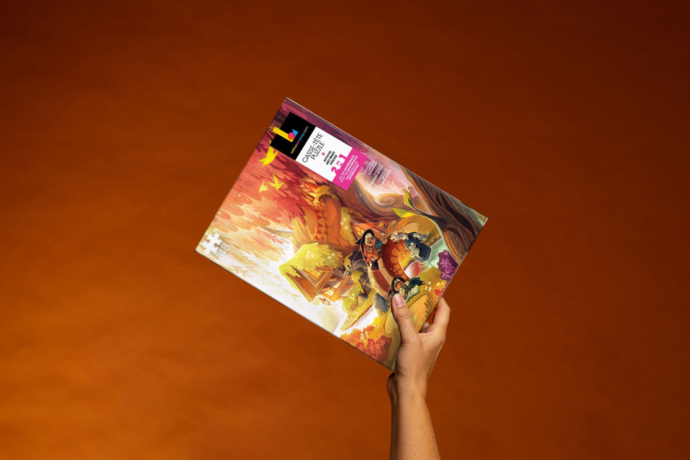 Hand holding the "Afternoon Play" 48-piece jigsaw puzzle box open, revealing the artwork.