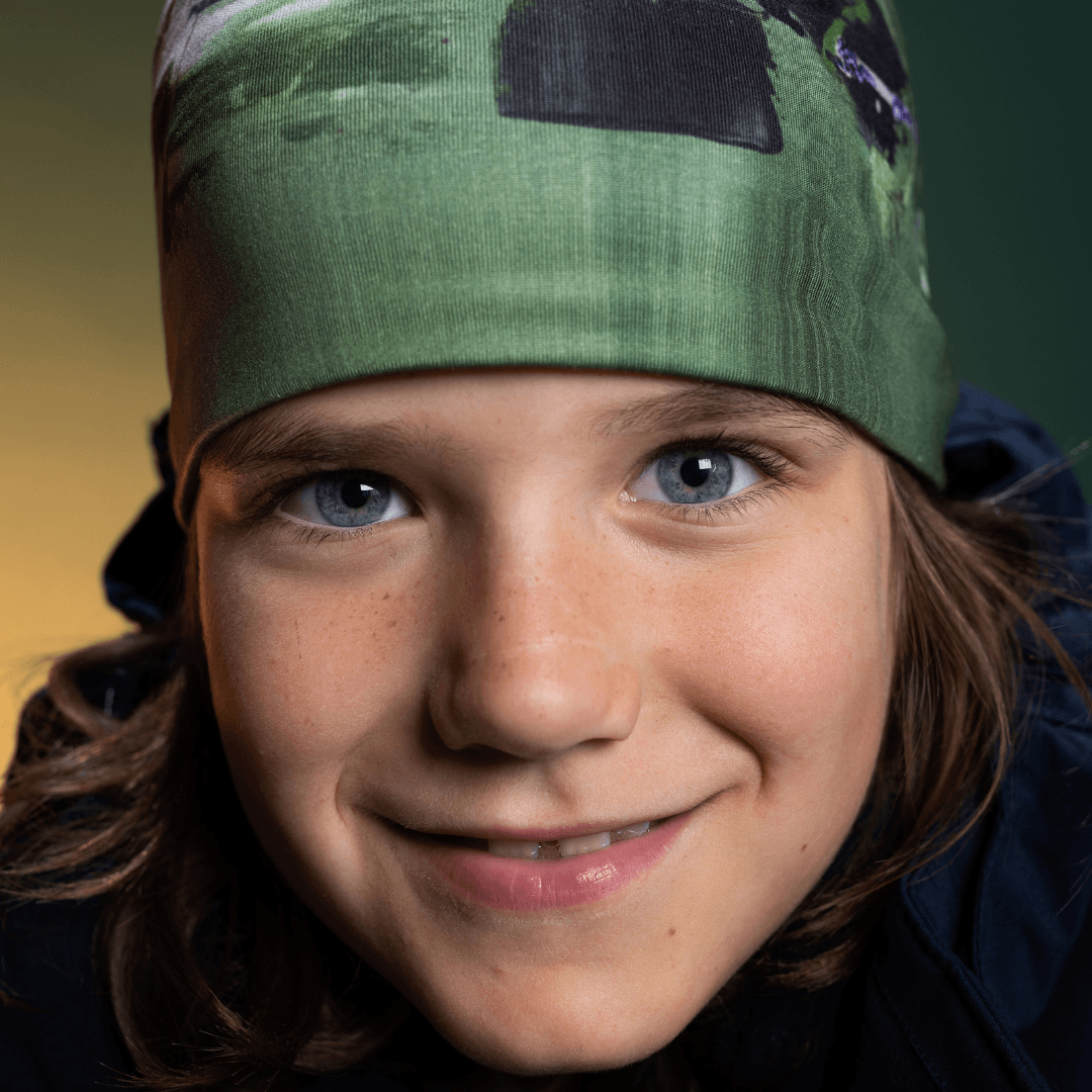 Close-up portrait of a young person wearing the Amazonia green beanie.