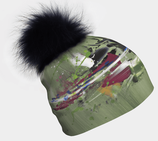 Amazonia Beanie with a large black fluffy pom-pom and a green abstract art print.