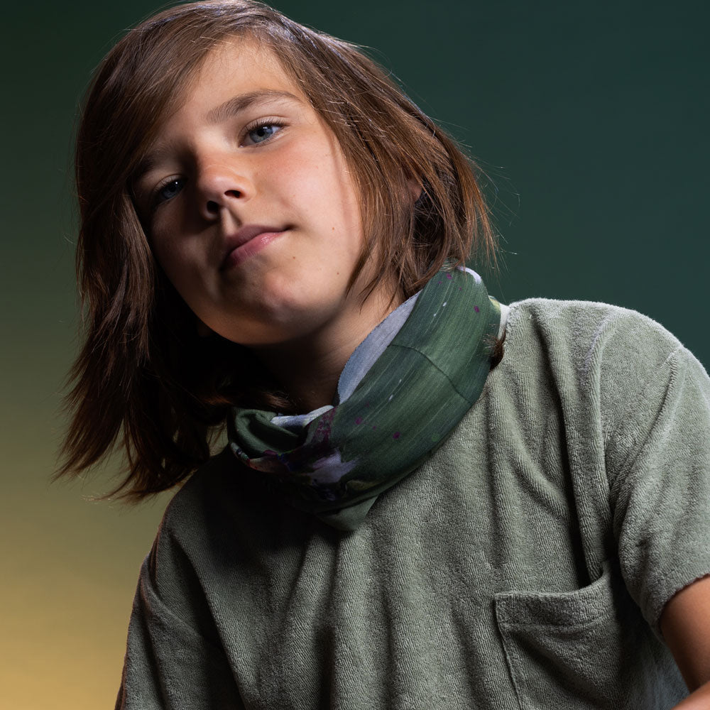 Child wearing the Amazonia Multifunctional Tube as a neck gaiter, styled with a sage green top — one size fits adults and kids