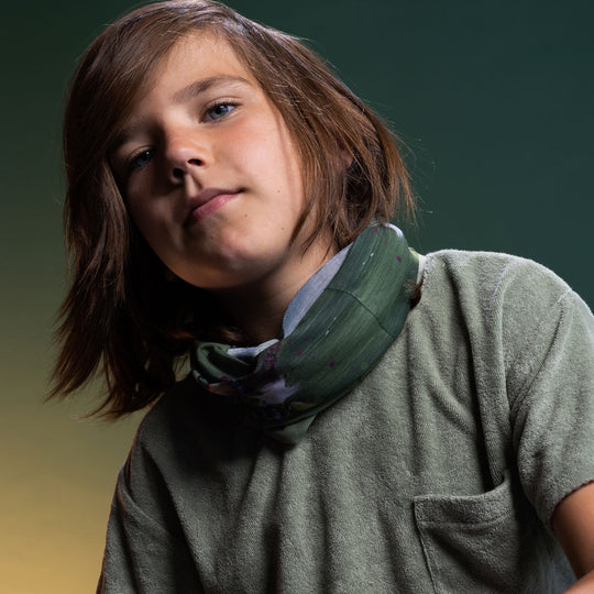 Child wearing the Amazonia Multifunctional Tube as a neck gaiter, styled with a sage green top — one size fits adults and kids