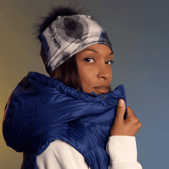 Femme regardant par-dessus son épaule, portant la tuque et la tuque Plumes bleues avec un veston d&