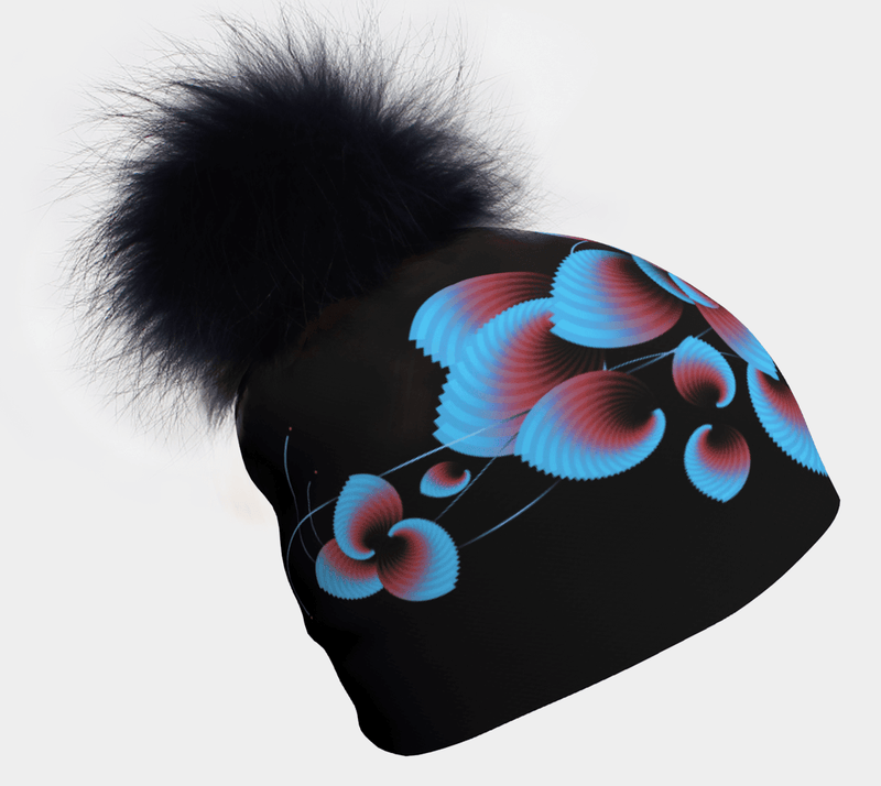 Black beanie adorned with blue and red abstract floral design, topped with a fluffy black pom-pom.