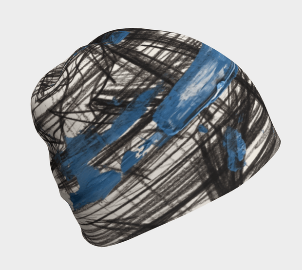 La nouvelle tuque Expressive Sketch de la collection AH25-26 présente une création unique d'Elise Charette avec des traits de pinceaux noirs et bleus.