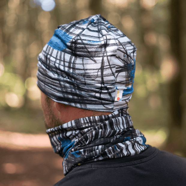 Man wearing the White, Black and Blue Expressive sketch sport beanie with assorted multifunctional tube from Lalita's Art Shop AW25-26 collection.