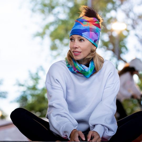 Woman wearing a white sweatshirt and the abstract pattern neck tube as a headband and around her neck.