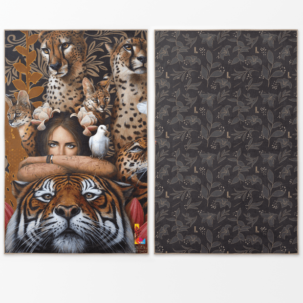 La serviette XL Felins par Sophie Wilkins est réversible : le recto est une illustration artistique d'une femme mystérieuse entourées de félins gracieux, dans les tons feutrés de brun, roux, orangé, noir et un style léopard moderne, alors que le verso est un motif de feuilles dans les tons de noir, gris, doré.