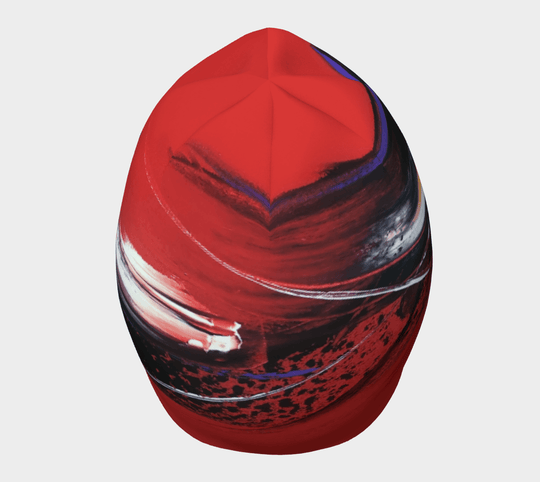 Red abstract art beanie with dynamic brushstrokes and speckles, viewed from the top.