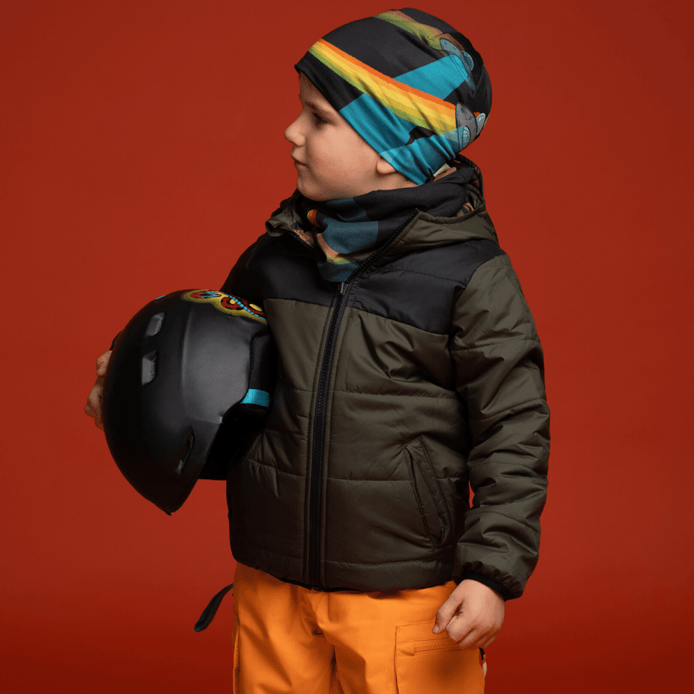 Young boy wearing the Flying Saucers beanie and a matching neck gaiter, holding a helmet.