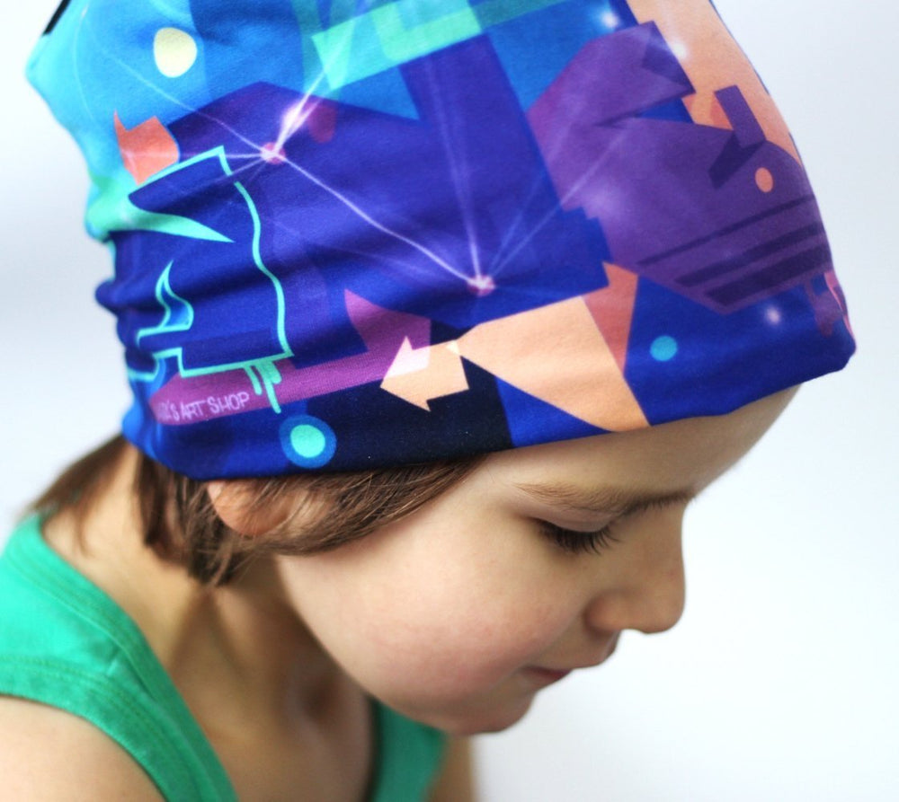 A child wearing the colorful Galaxy Beanie, which is pulled down over their forehead.