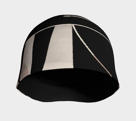 The interior of a black beanie with a geometric black, pink, and beige exterior pattern visible.