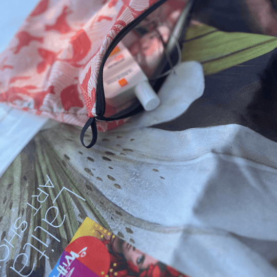 Close-up of the Guerrière Pacifique towel and its included pouch, showing sunscreen and toiletries.