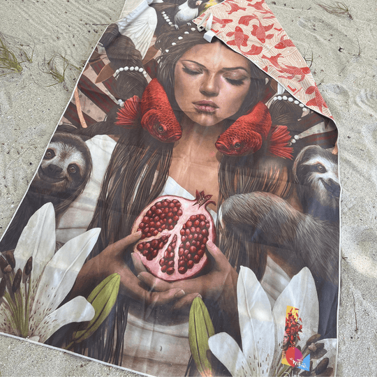 The Guerrière Pacifique towel laid out on sand, showing the artistic side with a woman and nature.