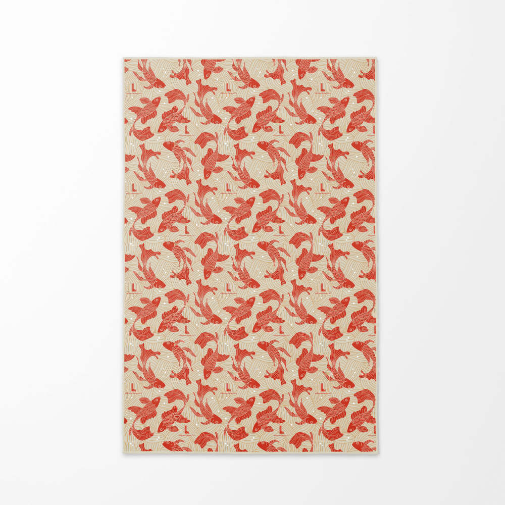 The reversible side of the Guerrière Pacifique towel, displaying a repeating pattern of red koi fish on a beige background.