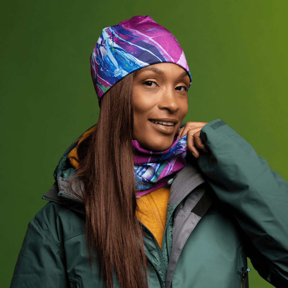 Woman wearing the Hope Beanie and matching neck tube with a green winter jacket.