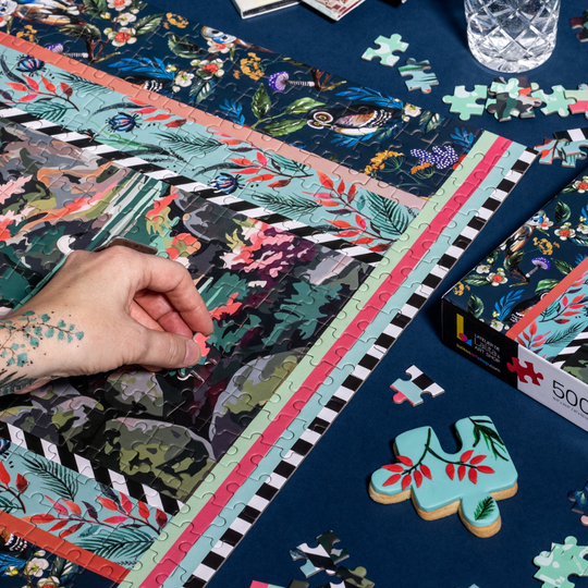 Close-up of a hand placing a puzzle piece into the Jigsaw Puzzle "Flying High" image.