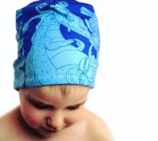 Close-up of a child wearing the Knights and Dragons Blue Beanie with a bright blue dragon design.