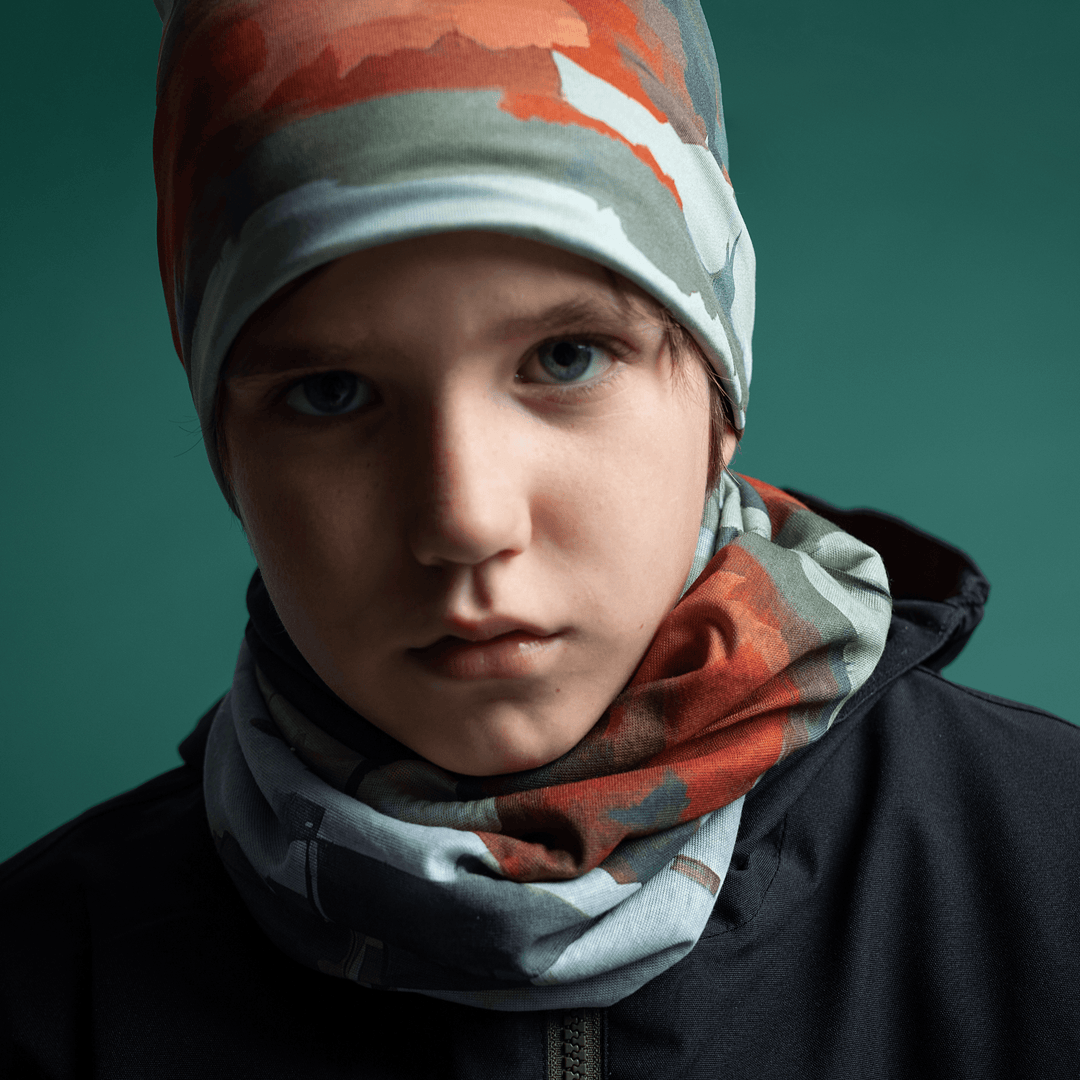 Close-up portrait of a young boy wearing the Lachine Beanie and neck tube.