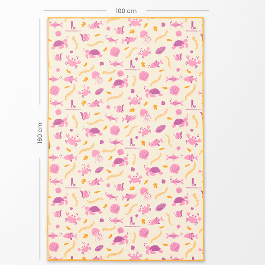 Côté inversé de la serviette de piscine La Petite Sirène pour enfants (160x100 cm) avec un motif répétitif de créatures marines roses et oranges et de corail sur fond crème.