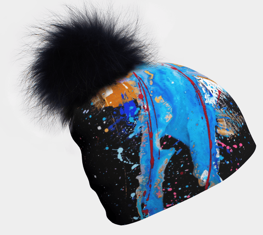 MatriX Beanie with black pompom, showcasing vibrant blue, red, and gold abstract paint splatters on a black background.