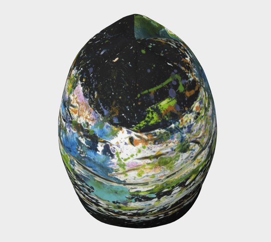 A black beanie showcasing a vibrant abstract art print with splatters of green, blue, and orange.
