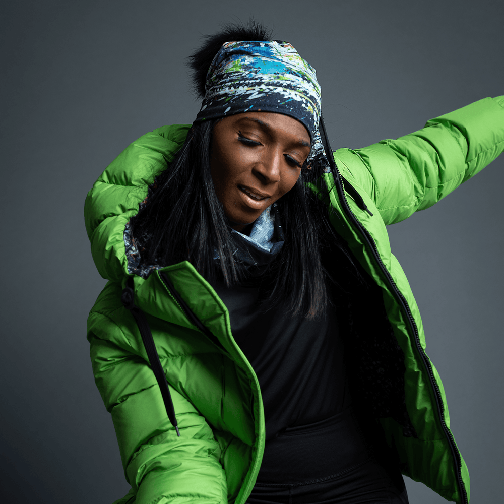 Woman wearing the Meduse Beanie as a headband with a green puffer jacket.