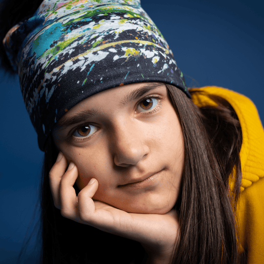Close-up of a young girl wearing the Meduse Beanie, showing the abstract design.