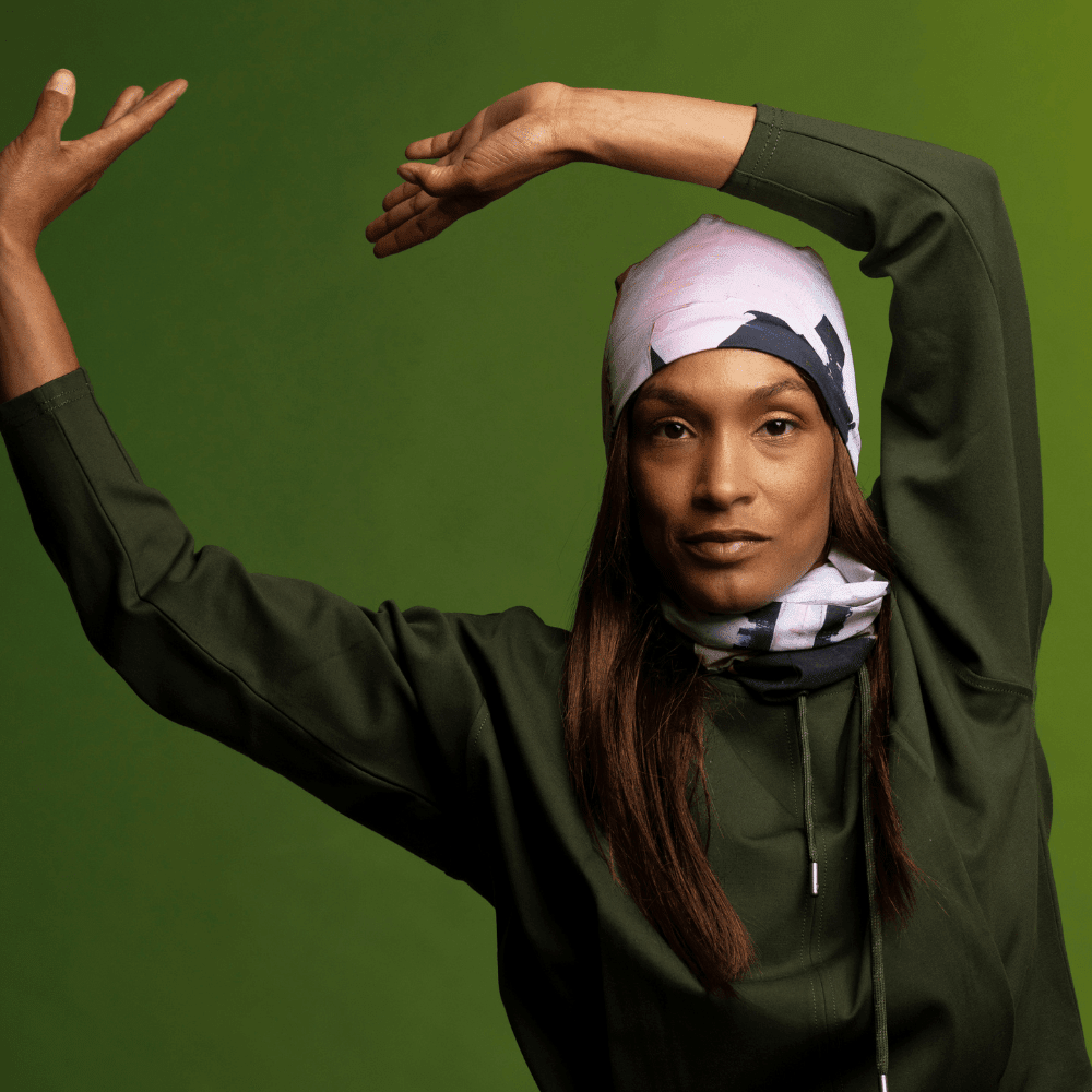 Model in a dark green top, posing with arms raised, wearing the modern quilt print as a bandana.