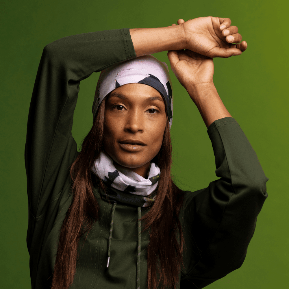Model in a dark green top, resting arms on head, wearing the modern quilt print as a bandana.