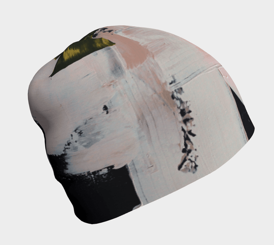 Close-up of a modern quilt beanie with abstract brushstrokes in pink, white, and black.