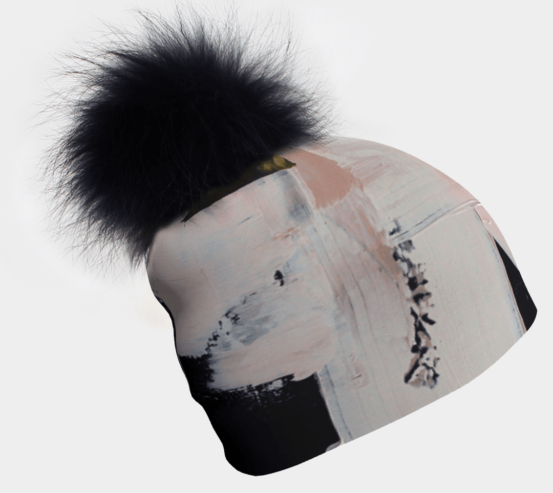 Beanie with a black pompom and abstract brushstroke art pattern