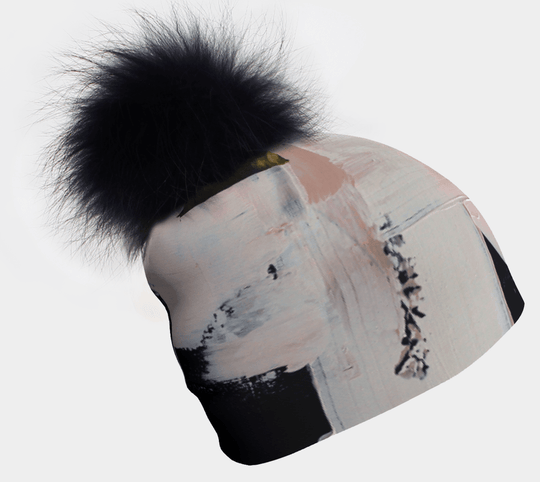 Beanie with a black pompom and abstract brushstroke art pattern
