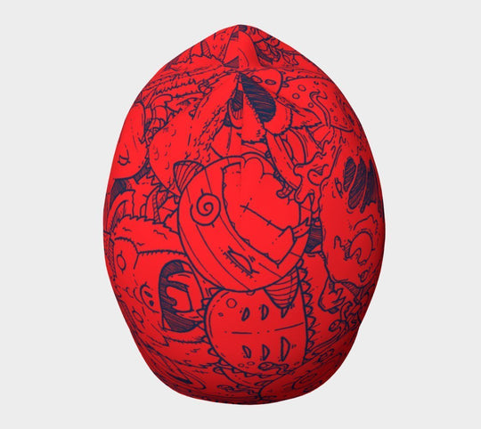 Red beanie with blue cartoon monster doodles, top view.