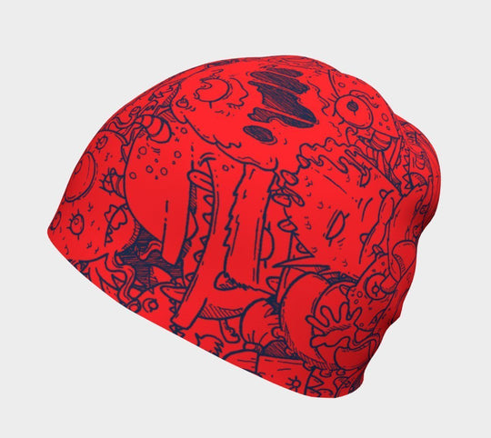 Close-up of the red beanie with blue cartoon monster doodles.