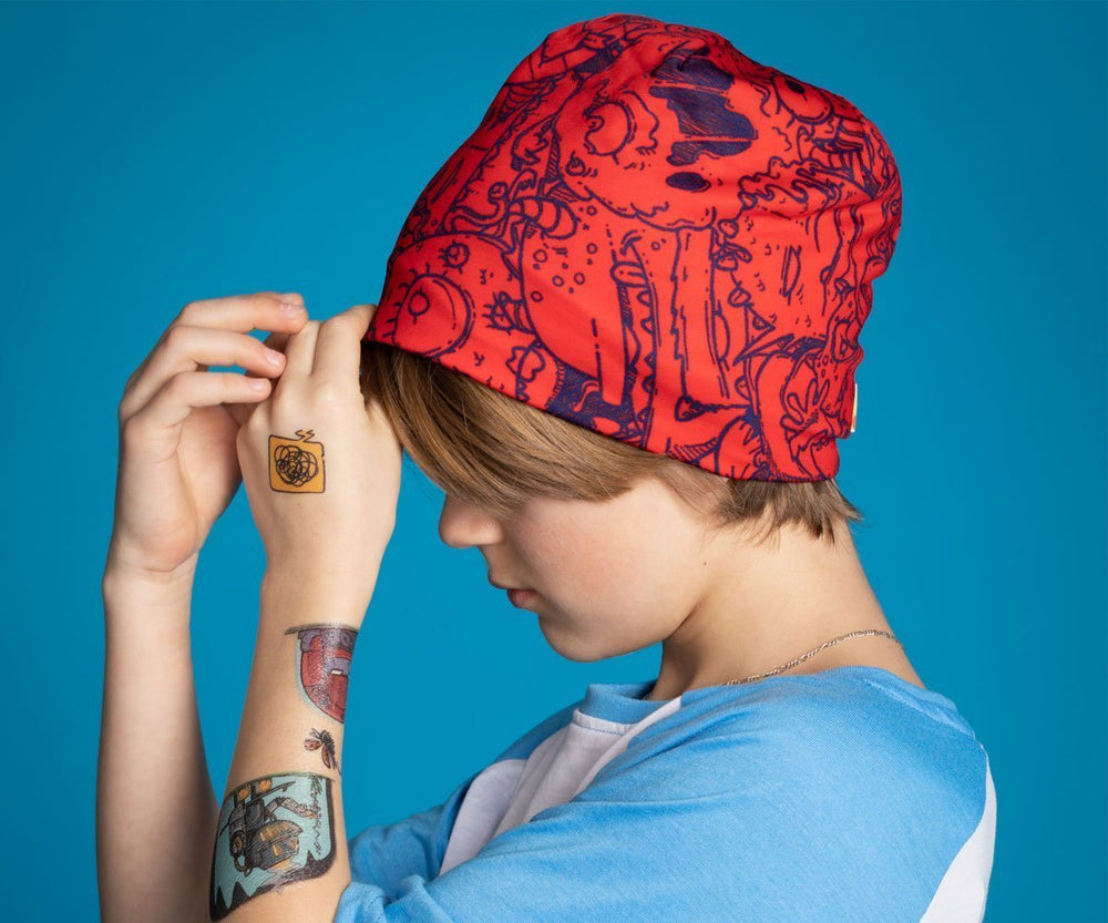 A child wearing the red monster beanie and looking down.