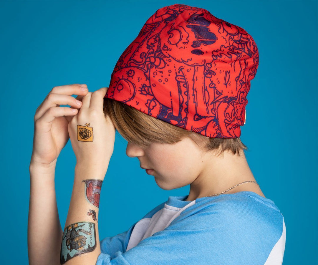 A child wearing the red monster beanie and looking down.