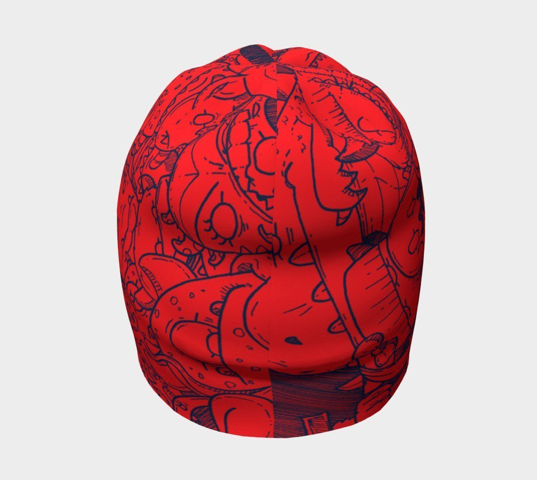Red beanie with blue cartoon monster doodles, side view.