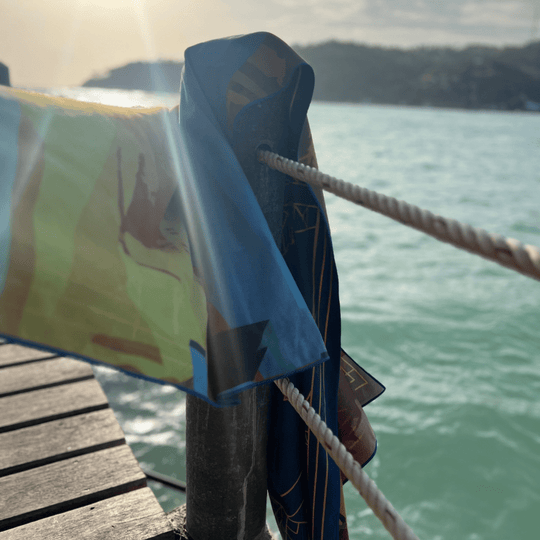 Montreal towel draped over a railing by the ocean, showing both art and geometric designs.