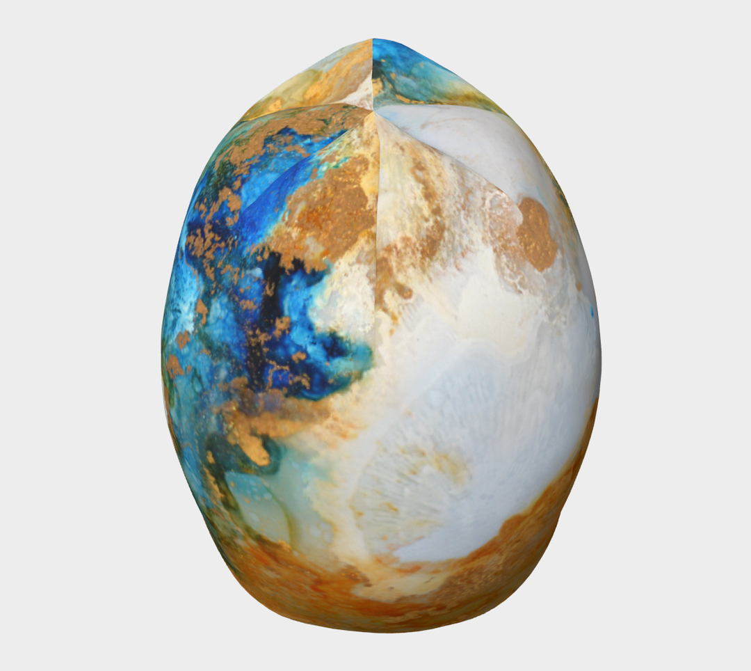 Top view of the Ocean Marble Beanie, showing the full circular design with swirls of blue, white, and gold.