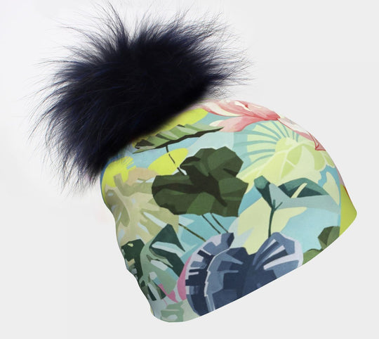 A colourful Pastel Flowers beanie with a large, dark blue fur pompom against a white background.