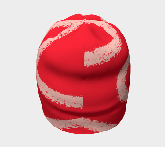 Red beanie with abstract peach-coloured swirl pattern, back view.