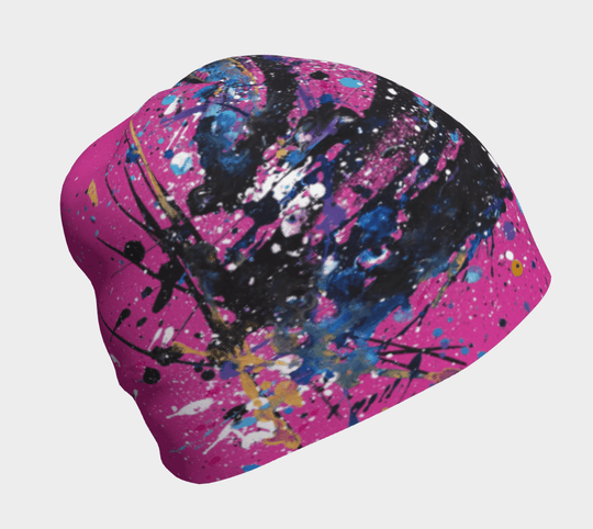 A pink beanie with an abstract black, blue, and white paint splatter design.