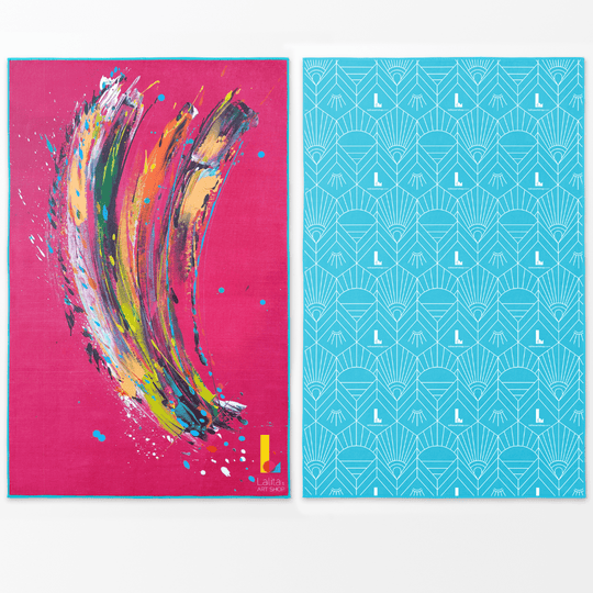 Oversized pink beach towel with abstract multicolor brushstrokes on one side and a geometric aqua pattern on the other.