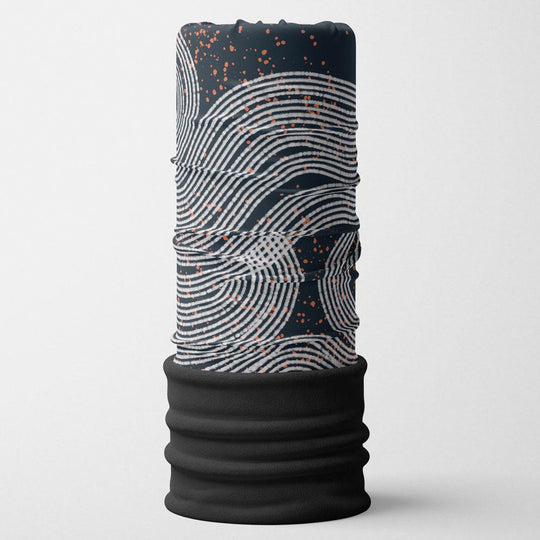 A stacked multifunctional neck tube with a dark navy base, white wavy lines, and orange speckles, featuring a black fleece bottom.