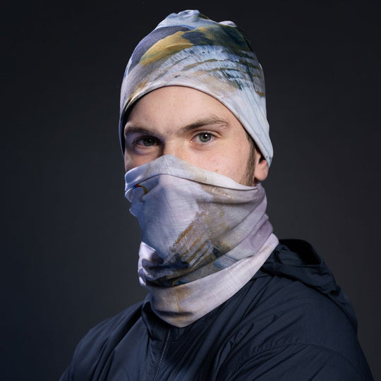 Man wearing a navy jacket, with the abstract art print fabric as a face mask and beanie.