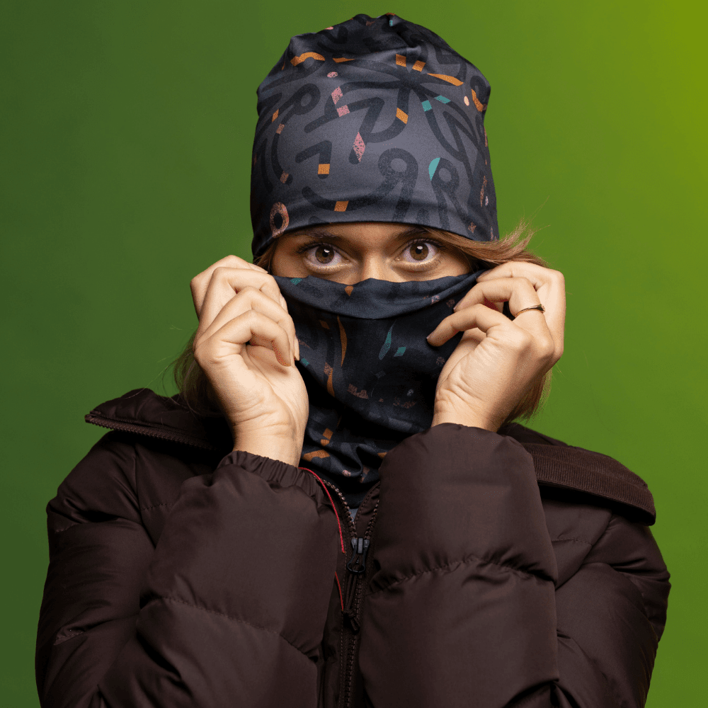 A woman wearing a winter jacket pulls a grey patterned neck tube up over her face, revealing her eyes.