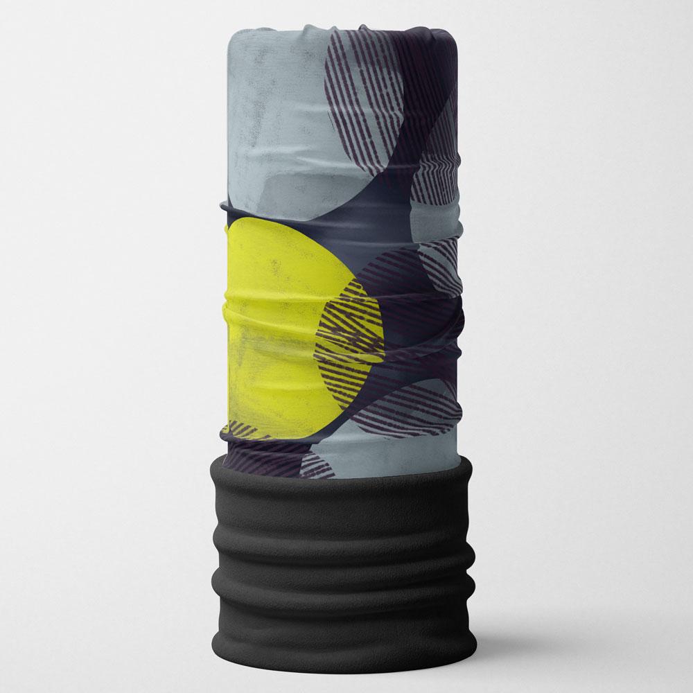 Close-up of a fabric tube with a gray background and abstract yellow and dark blue circles and lines, featuring a black fleece bottom.