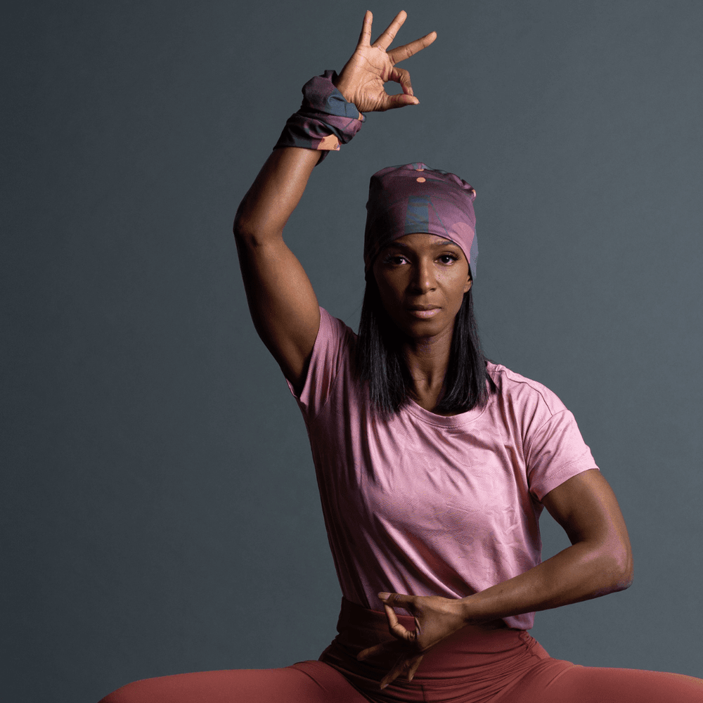 Woman wearing a Purple Geometrics Beanie and matching neck tube, performing a yoga pose.