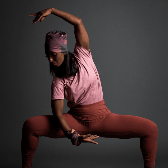 Woman in a deep squat pose wearing a Purple Geometrics Beanie and matching wristband.
